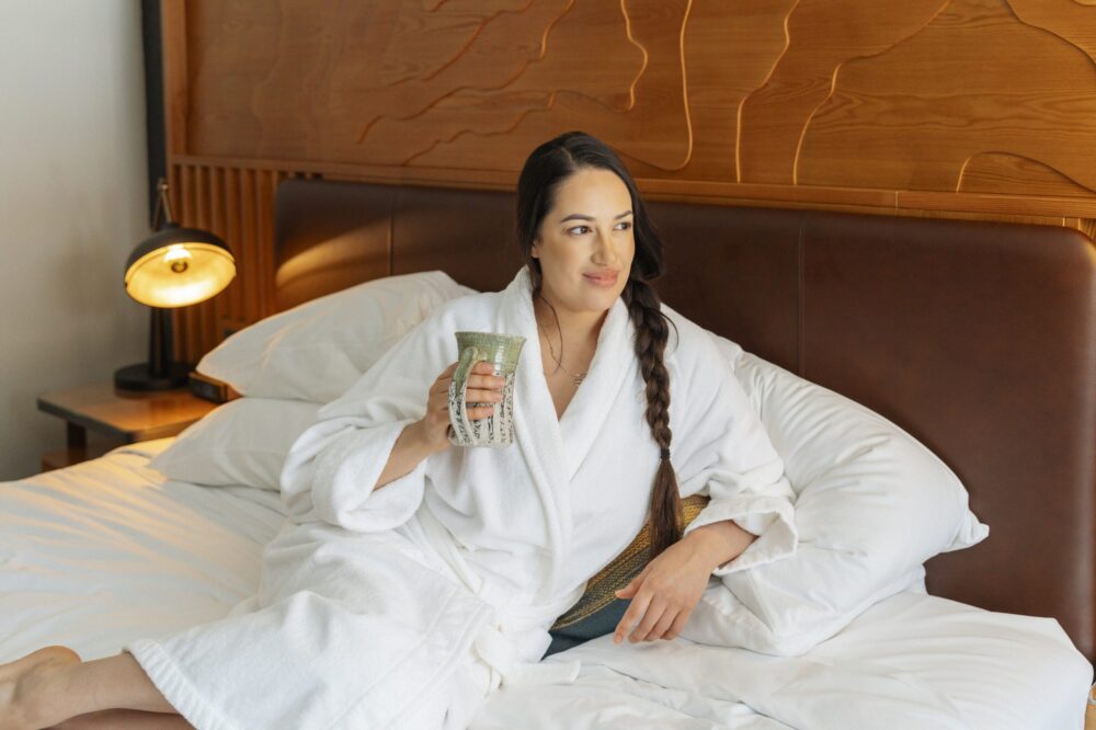 ANCJD Women in Robe on Bed low res